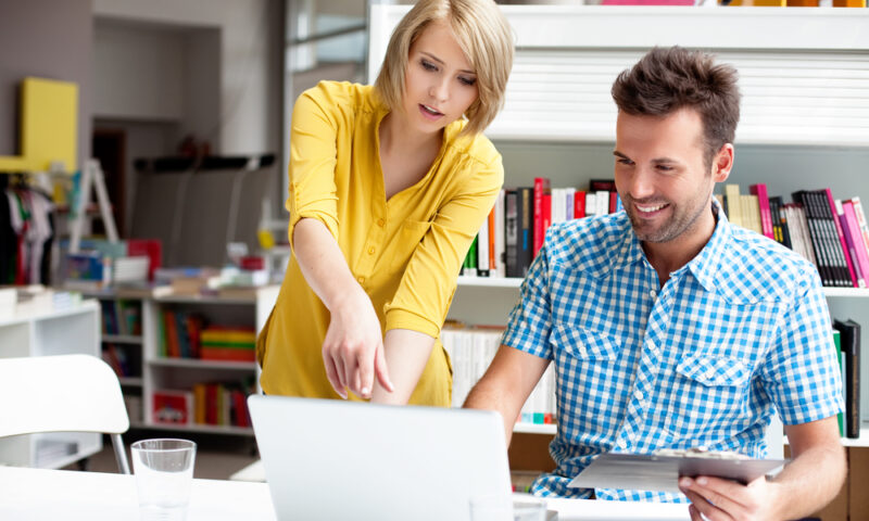 Two bookshop managers working on laptop