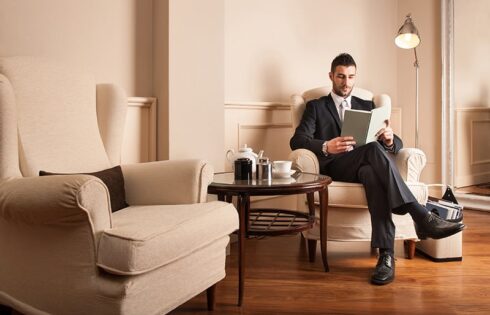 Young businessman relaxing reading a book