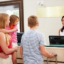 Family Checking In At Hotel Reception